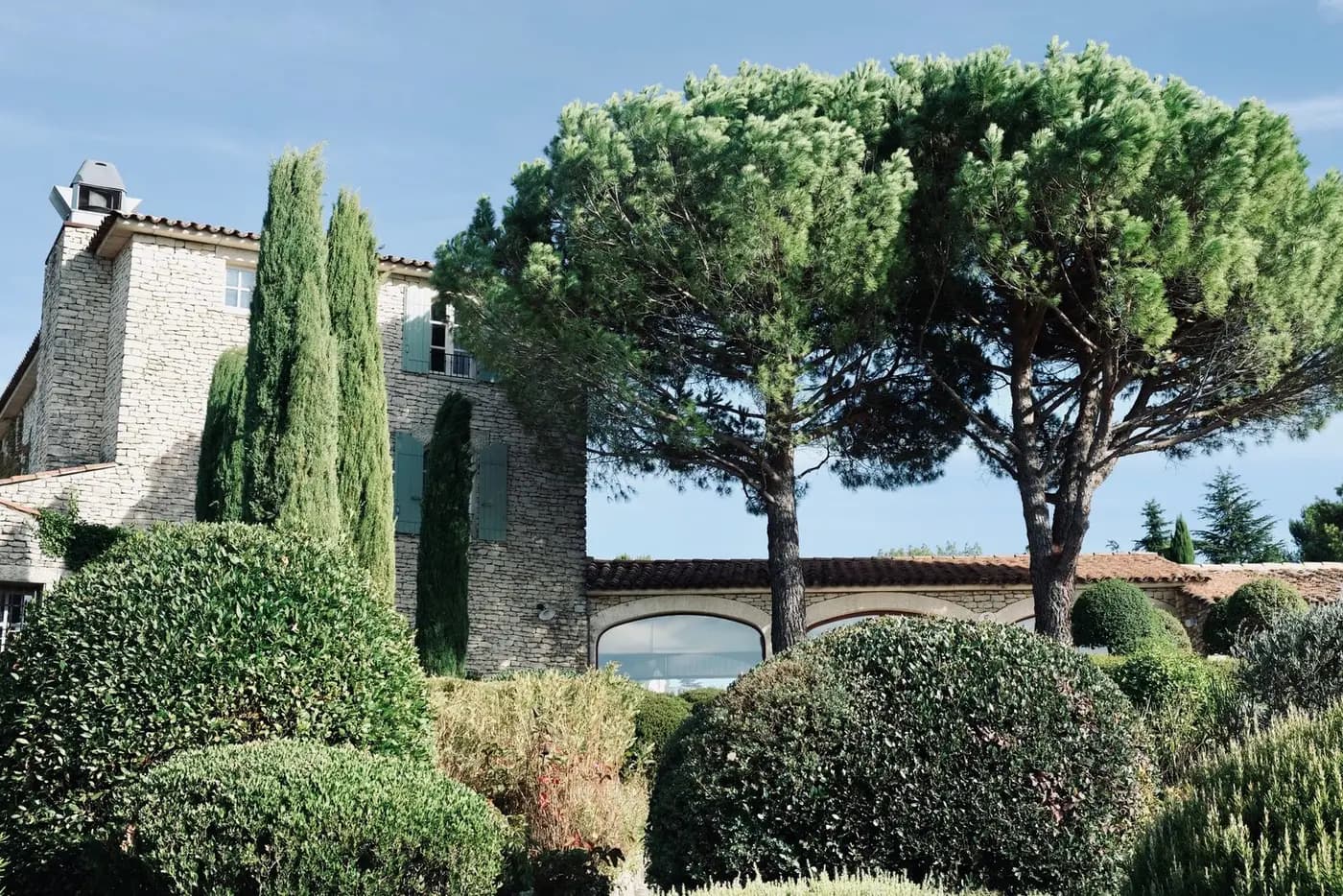 Bastide en pierre entourée de cyprès et de haies taillées, typique des environs d'Aix
